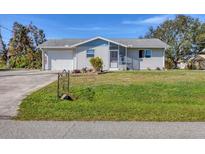 Single story home with attached garage and spacious lawn at 6383 Brookridge St, Englewood, FL 34224