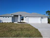 Single-story home with a two-car garage and a well-manicured lawn at 14331 Montmarte Ave, Port Charlotte, FL 33981