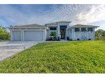 Beautiful contemporary home with three-car garage and lush lawn at 14351 Howard Ave, Port Charlotte, FL 33953
