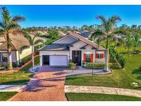 Single-story home with a brick driveway, two palm trees, and a lush lawn at 2148 La Palma Ave, Port Charlotte, FL 33953