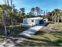 Aerial view of a single-wide mobile home with a shed and a spacious lot at 2930 Waterside Dr, Englewood, FL 34224