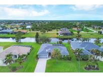 Aerial view of a canal front home with lush landscaping and a neighborhood view at 850 Boundary Blvd, Rotonda West, FL 33947