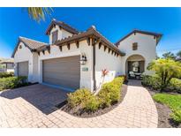 Two-car garage, paver driveway, and nicely landscaped entryway at 11249 Mc Dermott Ct, Englewood, FL 34223