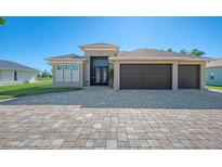 Two-story house with a three-car garage and a paver driveway at 634 Boundary Blvd, Rotonda West, FL 33947