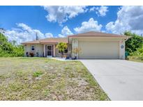 Charming single-story home featuring a two-car garage and well-maintained front yard at 4036 Elvington Rd, Port Charlotte, FL 33981