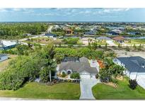 An aerial view of a stunning single Gathering home with a screened in pool, lush landscaping and great curb appeal at 15375 Taurus Cir, Port Charlotte, FL 33981