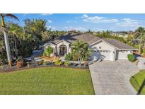 Single-story home with landscaped yard and two-car garage at 15375 Taurus Cir, Port Charlotte, FL 33981