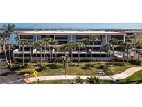 Aerial view of waterfront condo building with lush landscaping and water access at 1651 Beach Rd # 212, Englewood, FL 34223