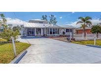 White house with a metal roof, screened porch, and a long driveway at 2075 Pennsylvania Ave, Englewood, FL 34224