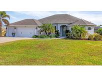 Single-story home with three-car garage and landscaped lawn at 241 Mariner Ln, Rotonda West, FL 33947