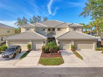 Front view of charming two-story home with attached garage and landscaping at 3303 Grand Vista Ct # 201, Port Charlotte, FL 33953