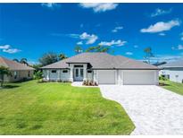 Attractive single-story home with a three-car garage and landscaped lawn at 35 Broadmoor Ln, Rotonda West, FL 33947
