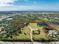 Aerial view of a large property with multiple buildings and a pond at 6341 Biggs St, Englewood, FL 34224