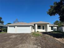 New construction home boasts a three-car garage, stucco exterior, and neutral color palette at 7351 Lighthouse St, Englewood, FL 34224