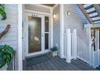 Inviting condo entry with glass door, light gray siding, and small deck at 7482 Palm Island Dr # 2511, Placida, FL 33946