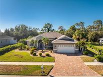 Charming single-story home with a paved driveway, attached garage, and lush landscaping at 112 Abercrombie Ave, Englewood, FL 34223