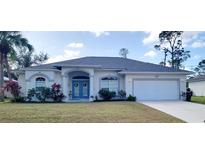 Charming single-story home with a welcoming front porch and landscaped yard at 1469 Purple Ln, North Port, FL 34286