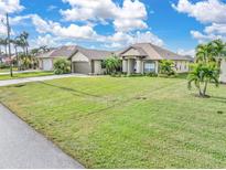 Single-story home with attached two-car garage and large lawn at 171 Medalist Rd, Rotonda West, FL 33947