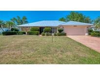 Beautiful single-story home with a metal roof, stone accents and well-manicured landscaping at 26098 Constantine Rd, Punta Gorda, FL 33983