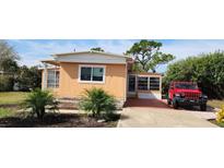 Peach-colored mobile home with white trim, a covered entryway, and landscaping at 3150 10Th St, Englewood, FL 34224