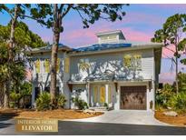 Charming two-story coastal home at dusk with mature trees and landscaping at 7064 Baypine Ln, Englewood, FL 34224