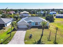 Charming blue home with landscaped yard and attached two-car garage at 9131 Berendo Ave, Englewood, FL 34224