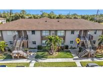 Aerial view of a condo building with two stories, brown roofs, and staircases leading to each unit at 25100 Sandhill Blvd # B-103, Punta Gorda, FL 33983