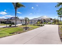 Beautiful single-story home with a concrete driveway, manicured lawn and landscaping, and metal roof at 646 Boundary Blvd, Rotonda West, FL 33947