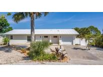 White single story home with attached garage and palm trees at 1493 Janet Pl, Englewood, FL 34223
