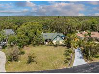 Charming home with a green roof, lush landscaping, and a spacious front yard, perfect for outdoor activities at 1828 Whispering Pines Cir, Englewood, FL 34223