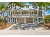 Beautiful two-story house with a white picket fence, driveway, and lush landscaping at 45 Seawatch Lake Dr, Boca Grande, FL 33921