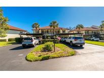 Two-story condo building with parking and lush landscaping at 502 Pine Hollow Cir # 502, Englewood, FL 34223