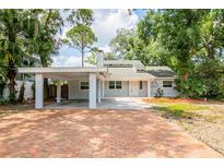Charming light blue house with brick driveway and carport at 7147 Lago St, Sarasota, FL 34241