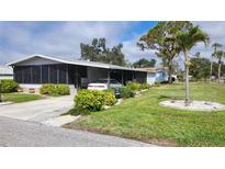 Charming single-story home featuring a screened porch, carport, and well-maintained landscaping at 735 Summersea Ct, Englewood, FL 34223
