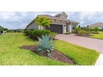 Landscaped front yard with brick pavers and lush greenery at 10958 Trevino St, Englewood, FL 34223