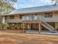 Charming stilt home featuring a metal roof, a front porch with chairs, and an outdoor recreation area at 7475 Manasota Key Rd, Englewood, FL 34223