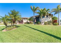 Stunning single-story home featuring lush lawn, mature palms, and a private two-car garage at 214 W Pine Valley Ln, Rotonda West, FL 33947