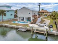 Beautiful stilt home featuring a waterfront view, private pool, boat lift, and a convenient outdoor bar at 10451 Sherman St, Englewood, FL 34224