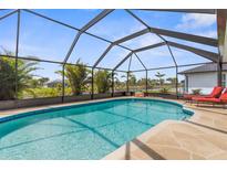 Relaxing screened-in pool with tropical plants and lounge chairs, perfect for enjoying the Florida sunshine at 254 Mark Twain Ln, Rotonda West, FL 33947