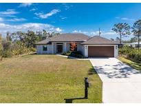 Lovely single-story home with a well-kept lawn, a two-car garage, and a simple front garden at 7442 Clearwater St, Englewood, FL 34224