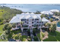 Stunning waterfront home with a white metal roof, lush landscaping, and multiple balconies overlooking the water at 11000 Placida Rd # 301, Placida, FL 33946