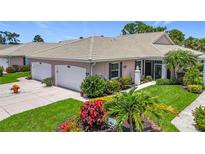 Charming villa with a well-manicured lawn, colorful flowerbeds, and a two-car garage at 1577 Monarch Dr # 1577, Venice, FL 34293