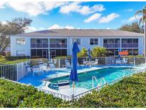 Community pool with ample seating and umbrellas surrounded by well-maintained landscaping at 5725 Greenwood Ave # 8101, North Port, FL 34287