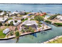 Waterfront home with a screened lanai, seawall, dock and mature tropical landscaping at 232 Bahia Vista Dr, Englewood, FL 34223