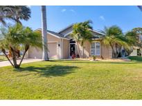 Charming single-story home with a well-maintained lawn and lush tropical landscaping, creating inviting curb appeal at 100 Hobo Rd, Rotonda West, FL 33947