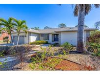 Charming single-story home with a well-maintained yard and tropical landscaping, offering curb appeal and a welcoming entrance at 1087 Bay Harbor Dr, Englewood, FL 34224