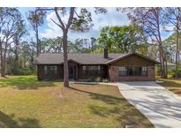 Charming single-story home with a brick facade and a well-maintained front lawn at 3892 Alwood St, North Port, FL 34291