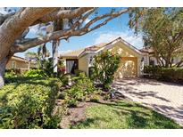 Charming home with a terracotta roof, well-manicured landscaping, and a brick driveway at 10508 Crooked Creek Dr, Venice, FL 34293