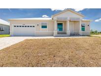 Beautiful single-story home with a white metal roof, a garage, and xeriscaping at 10688 Mcalester Cir, Port Charlotte, FL 33981