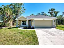 Charming single-story home featuring a two-car garage, landscaped front yard, and a welcoming facade at 1183 Cedar Ave, Englewood, FL 34223